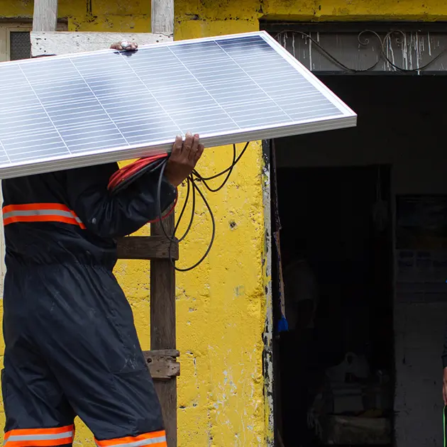 2125 Man On Ladder Holding Solar Panel Alterna Energica Solar Copyright James Rodríguez Panos Banner