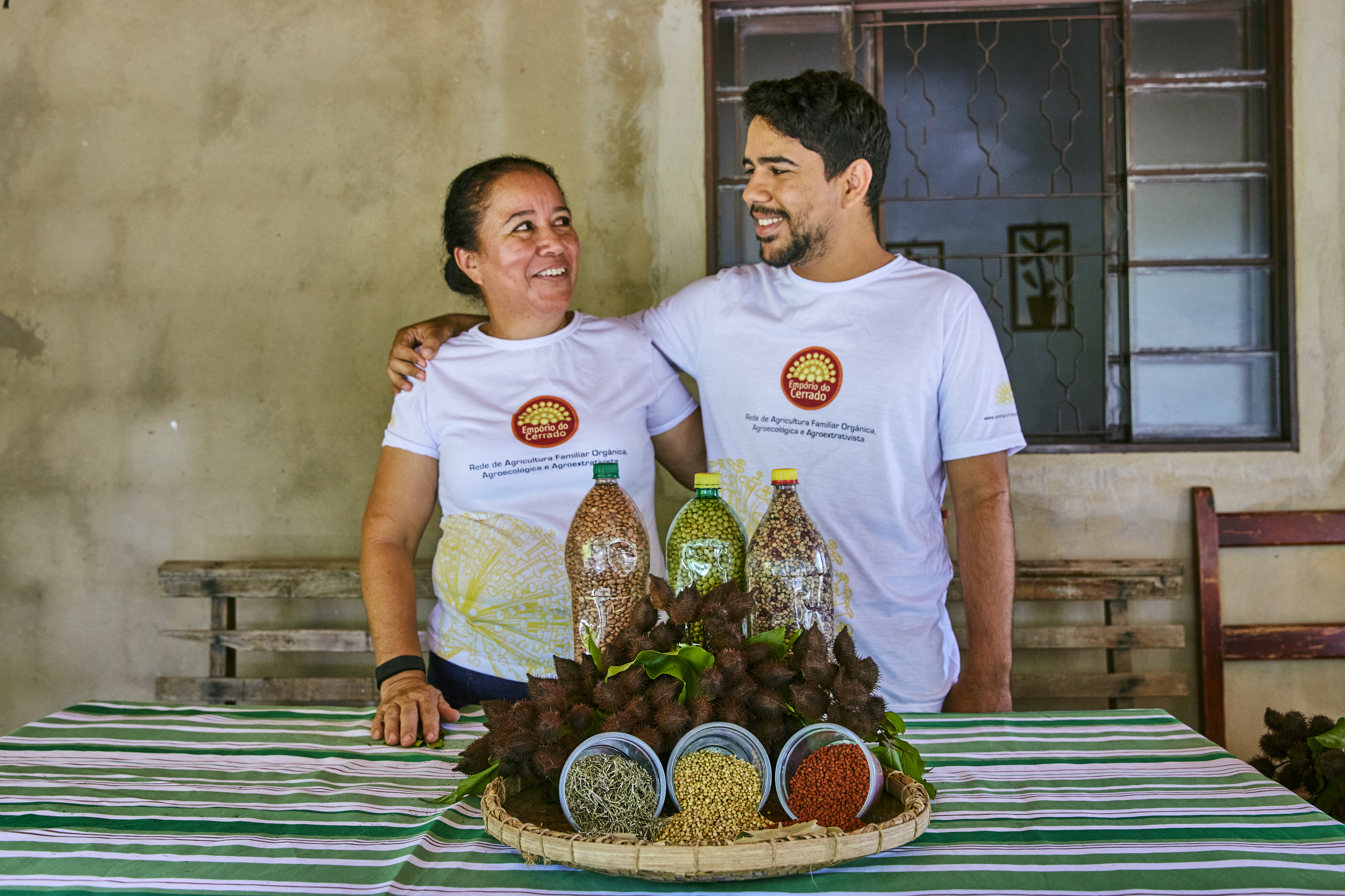 Man and woman standing behind a table with bottled grain on