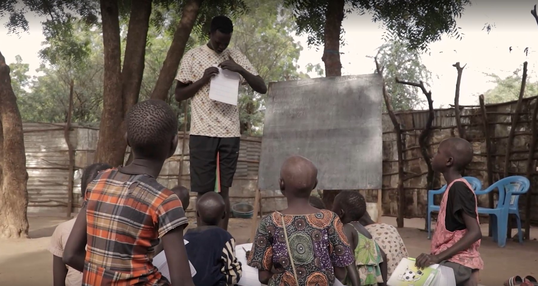 Man teaching children in Kakuma refugee camp