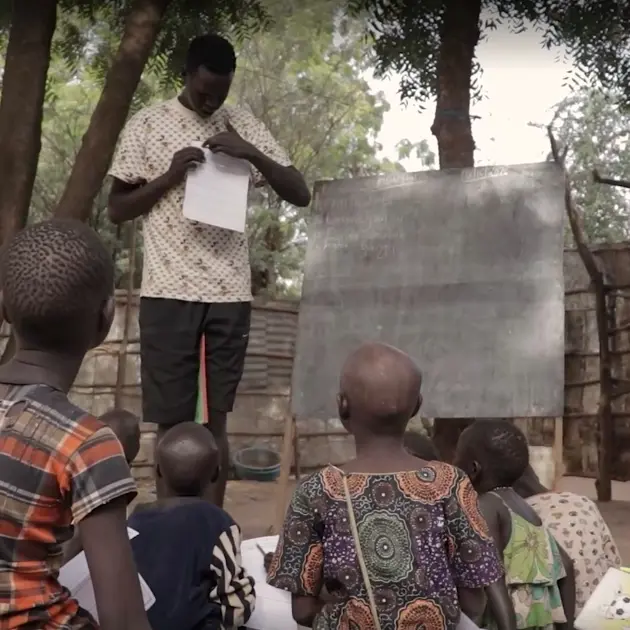 Man teaching children in Kakuma refugee camp