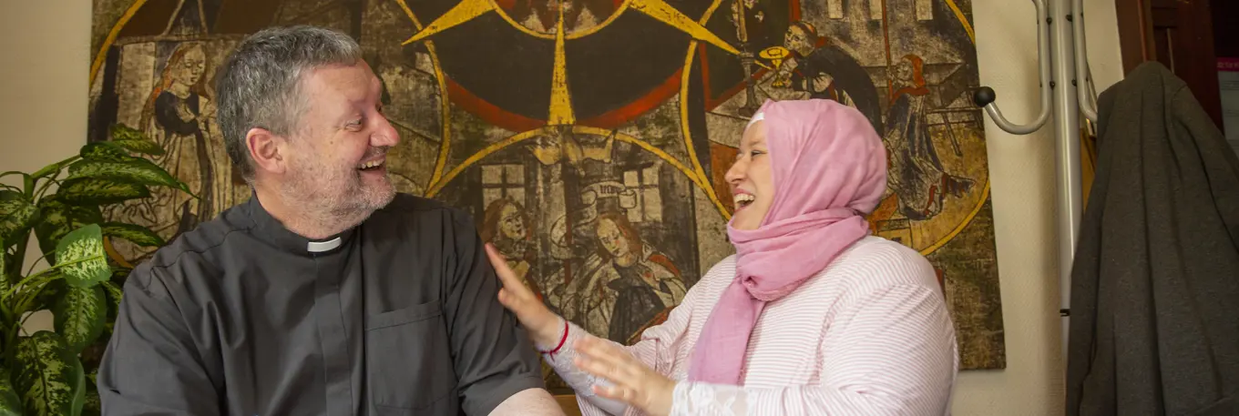 Priest and woman laughing